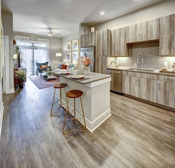 A kitchen with a white island and wooden cabinets.